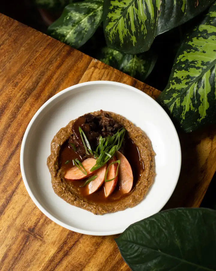 Braised oxtail with demi-glace and pickled radishes over cauliflower purée